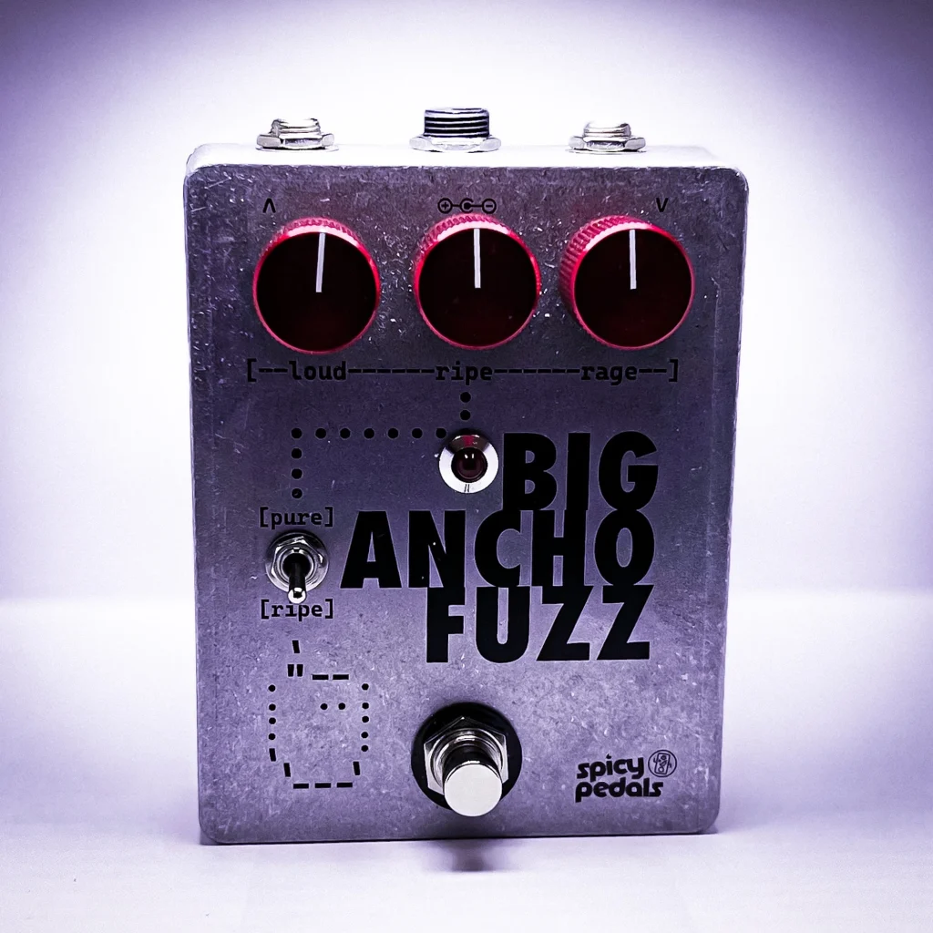 Big Ancho Fuzz lit by a purple key light, seen from three quarters, the aluminium enclosure and dark red knobs against a violet glow.