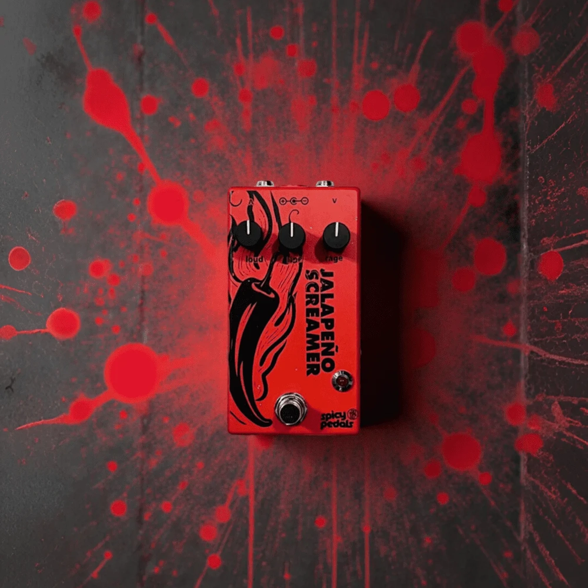Jalapeño Screamer Rojo on a dark ground with red splatter marks around it, seen from the front, black knobs and chilli illustration.