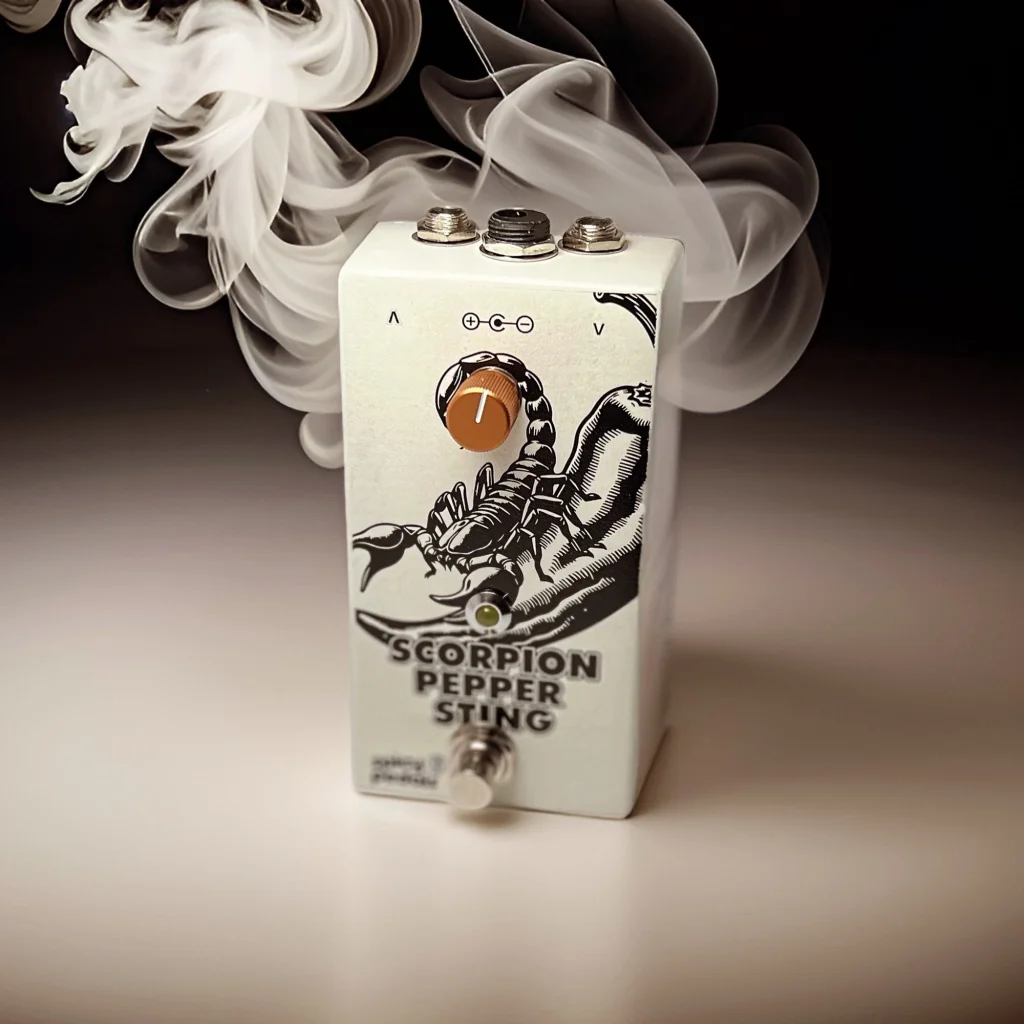 Scorpion Pepper Sting on a white surface with a plume of white smoke rising behind it, seen from the front, its single orange knob and lit LED in view.