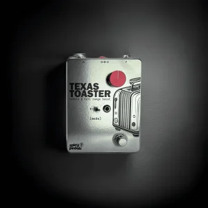Texas Toaster on a dark ground inside a circular pool of light, seen from the front, its red knob and the toaster line drawing standing out against the darkness.