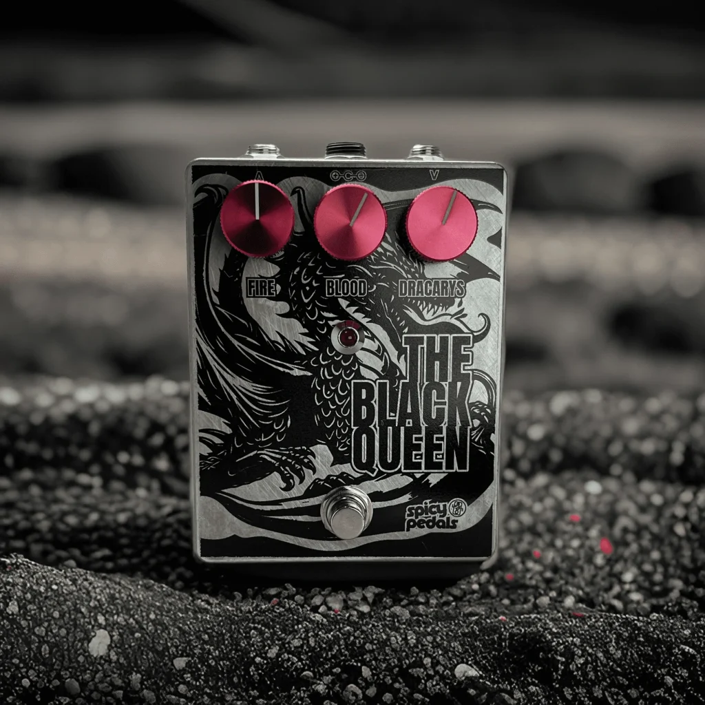 The Black Queen standing on grey gravel in near-monochrome light, seen from the front, the three pink knobs the only colour in the frame.